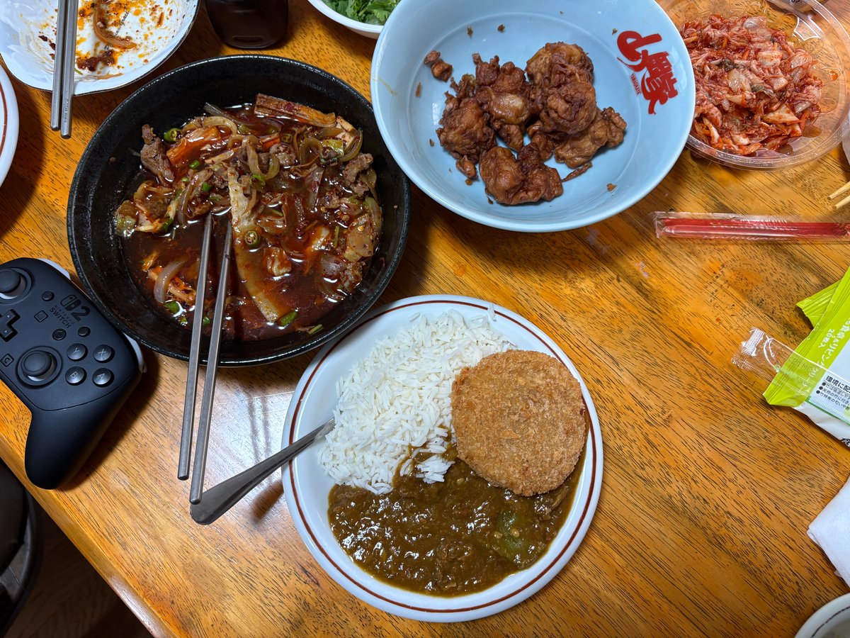 湯葉を使った赤い中華料理、唐揚げ、メンチカツを添えたカレーが並ぶ食卓