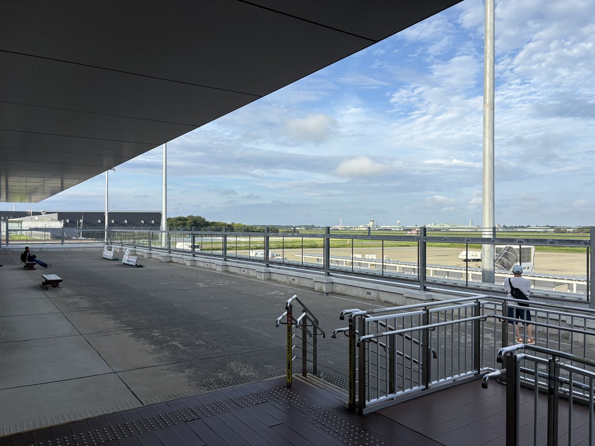 茨城空港の展望デッキから見た滑走路と青空。手すりの向こうにエプロンが広がる