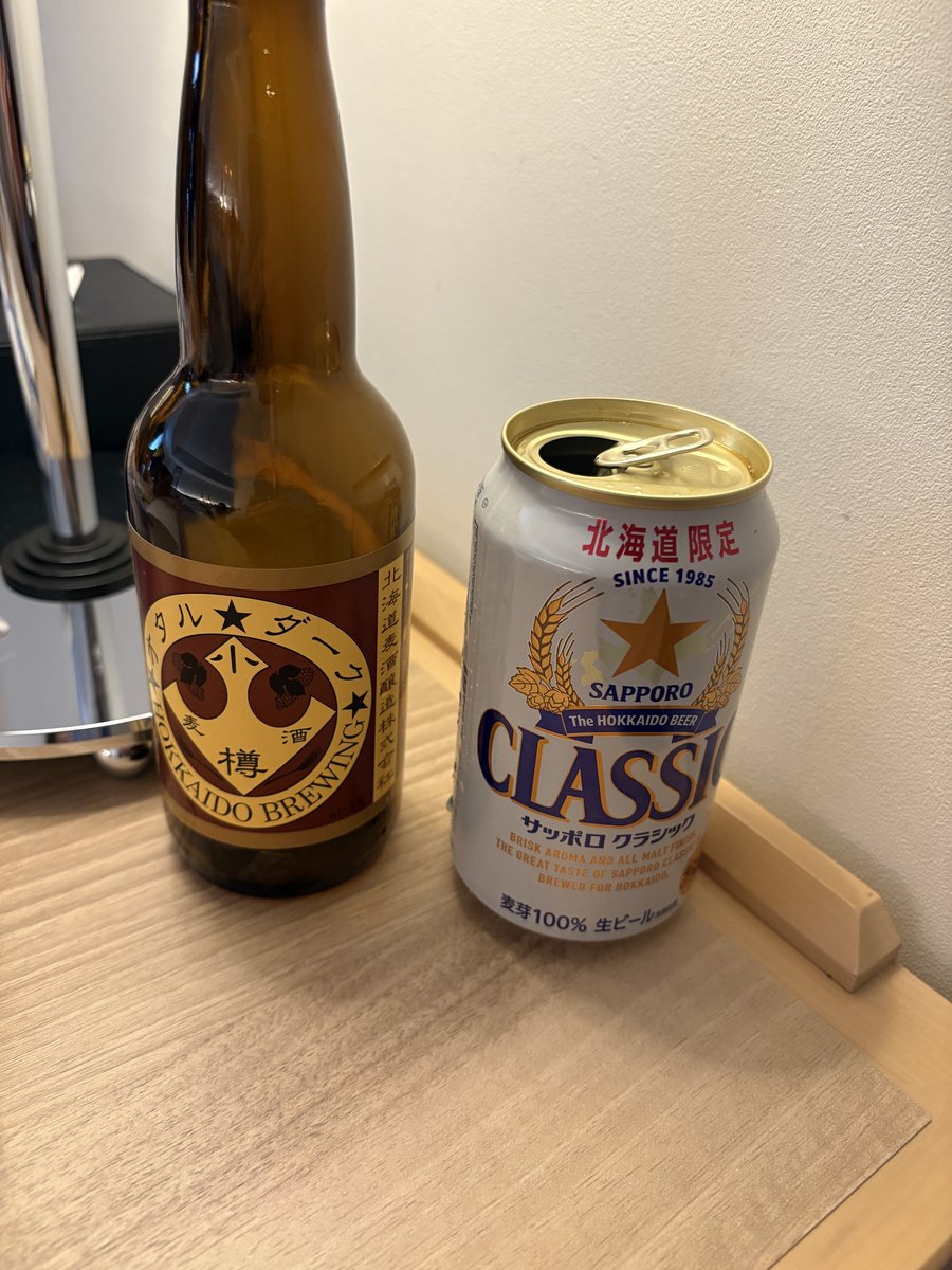 部屋の机に並べた小樽ダークの瓶ビールと、北海道限定サッポロクラシックの缶ビール