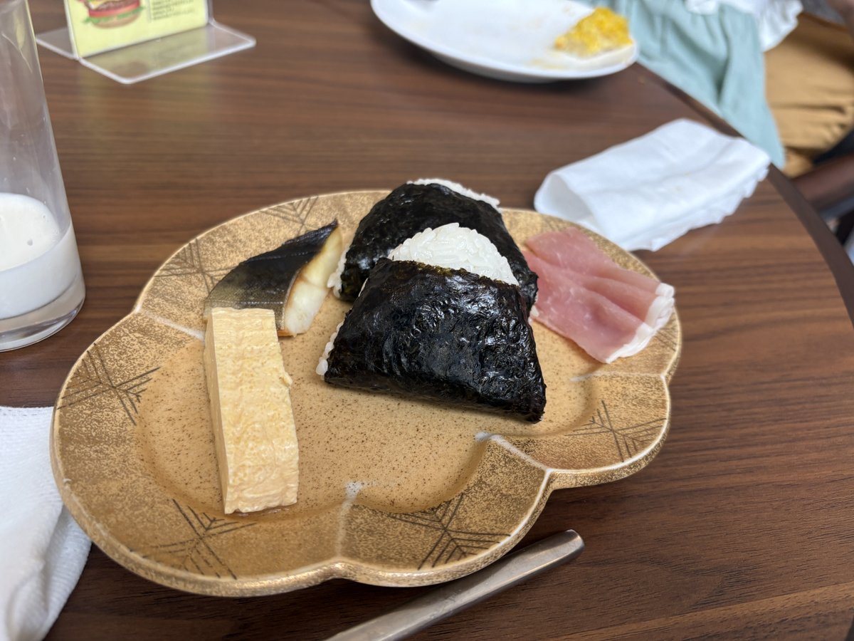 おにぎりと魚、卵焼き、生ハムを載せた朝食プレート