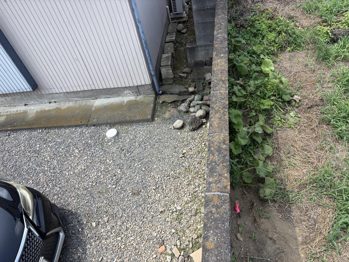 ブロック塀際に打たれた境界杭とピンクテープ