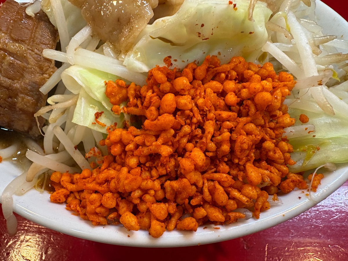 小ラーメンの端に盛られた赤い辛揚げのアップ